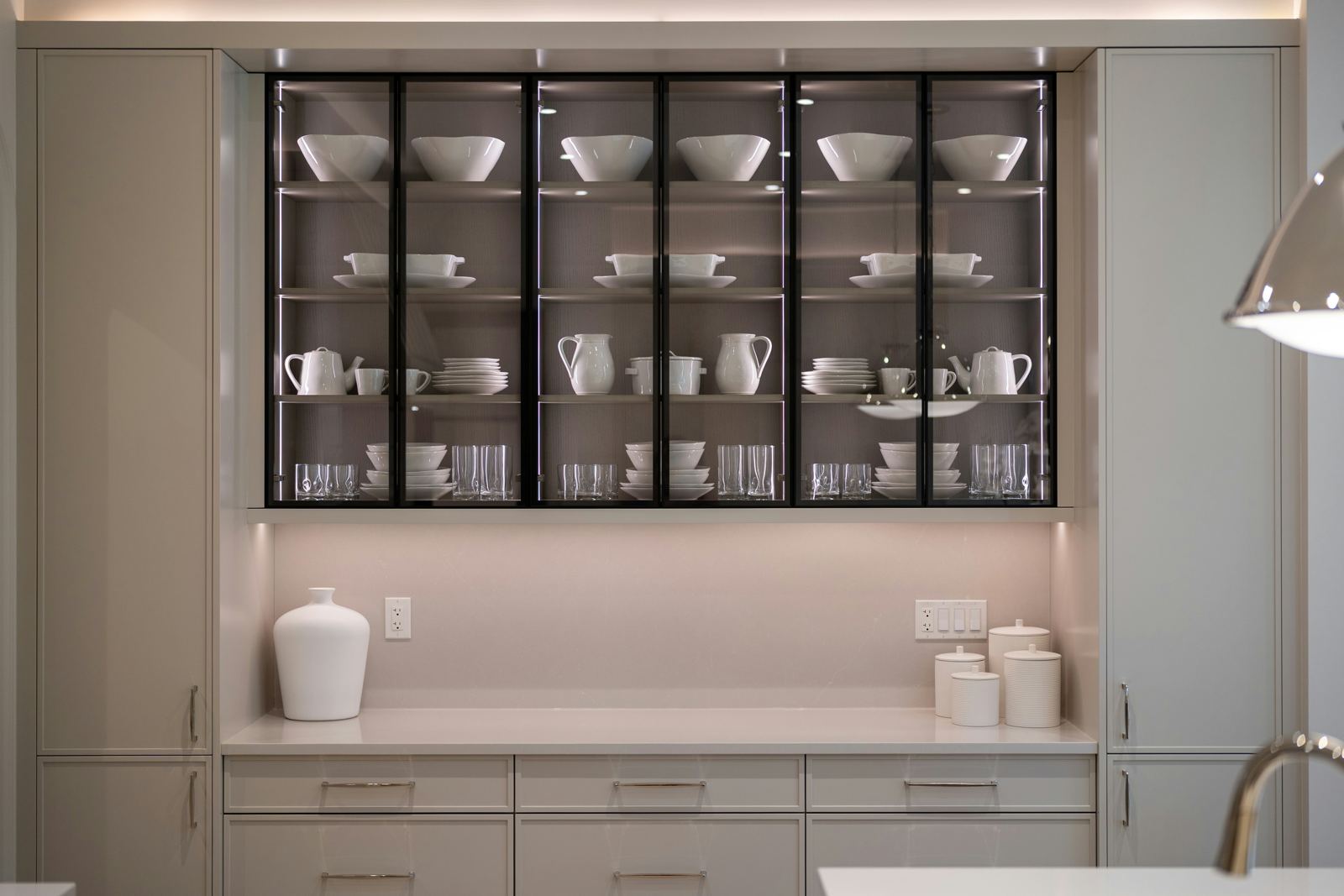 Organized glass-front kitchen cabinet with neatly arranged dishware